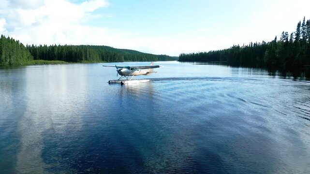 Floatplane landing on secluded lake amid dense forest and morning mist, smooth gliding in serene wilderness