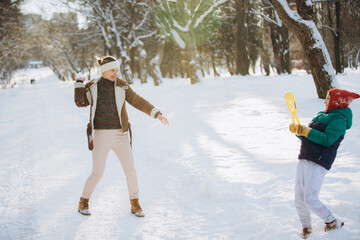 Mother son playing snow games in winter park