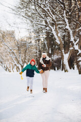 Fototapeta premium Happy mother son running, playing in winter park