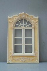 This elegant golden window frame adds a touch of luxury to the minimalist gray wall.