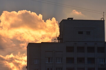 Sunset over the city. The rays of the sun break through the clouds