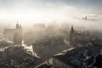 Panorama of Old Town in Krakow (visible Saint Mary Basilica - Mariacki Church, Sukiennice - Cloth Hall, Town Hall, Wawel Castle and Main Market Square) in morning fog. Softlighted