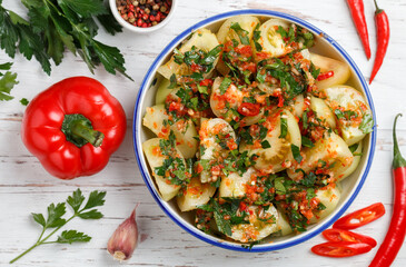 A spicy, savory snack made from fresh vegetables - green tomatoes, red bell pepper, hot chili pepper, garlic, parsley and spices. Salad. Selective focus