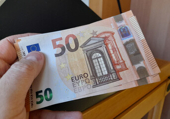 Banconote da 50 che passano da una mano all'altra - business o tangente