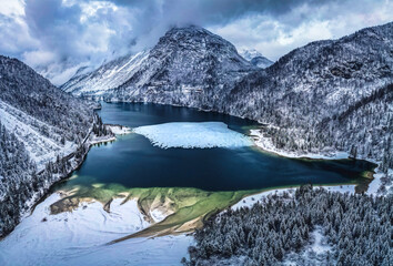 Winter magic in the Julian Alps. Lake Predil seen from above. Between snow and ice.