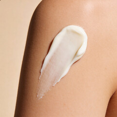 swatch of white cream on skin background, macro texture of the skin on which the cream is applied	