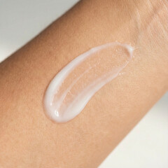 swatch of white cream on skin background, macro texture of the skin on which the cream is applied	