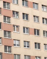 Fototapeta premium Modern residential building with multiple windows in a city setting during daylight hours
