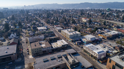 Aerial view of rooftops and roads create a textured tapestry under a soft winter sky, North Killingsworth Street, Portland, Oregon, United States.