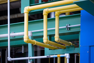 The yellow chemical pipelines inside the factory are arranged in an orderly and engineered manner, representing precision,