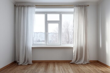 Empty room interior features large window dressed with sheer pale curtains overlooking an urban winter scene