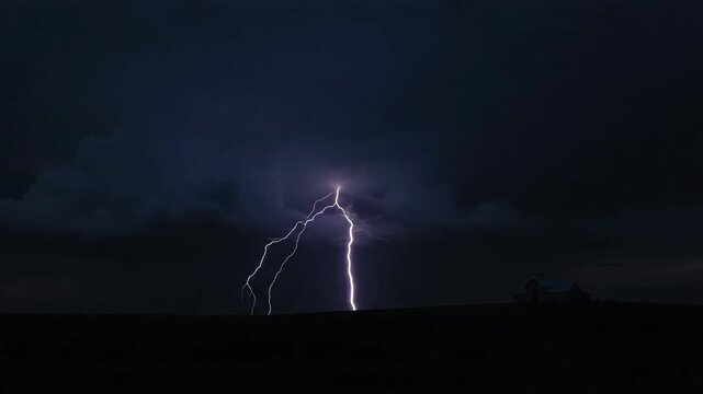 Intense lightning strike illuminating small structure against dark storm clouds over flat landscape