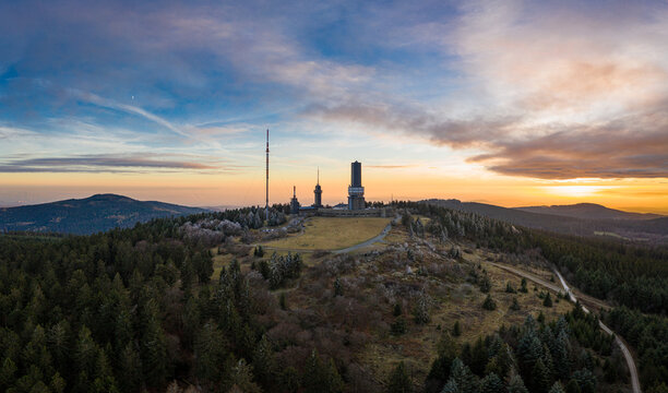 Aerial view of the Grosser Feldberg summit kissed by the soft glow of sunset, its towers standing tall amidst the frosted landscape, Schmitten im Taunus, Hessen, Germany.