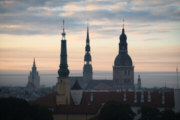 Blick &uuml;ber die D&auml;cher von Riga in Lettland in der dunstigen Morgend&auml;mmerung mit den Turmspitzen mehrerer Kirchen in den Silhouetten