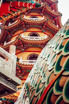 View of the vibrant, tiered pagoda rises majestically, adorned with intricate details, contrasting with the serpentine scales in Taipei City, Taipei City, Taiwan.