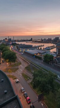 Aerial panoramic view over Maashaven day to night transition timelapse with moored ships, Katendrecht and Maas River in Rotterdam. Traffic near former factory converted into office and event space