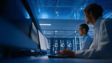 A cloud data center humming under blue ambient lights as technicians perform overnight maintenance on server racks — continuous computing power, digital infrastructure uptime, and seamless cloud - Powered by Adobe