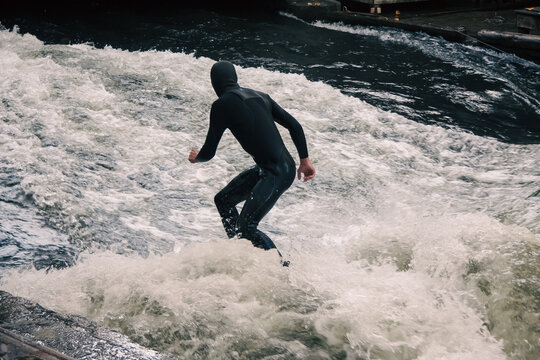 River surfer riding a standing wave on an urban river in Munich, Germany