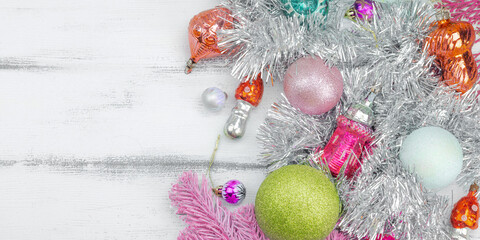 Trendy Kitschmas background. Vintage New Year balls, pink fir tree branches, silver garland