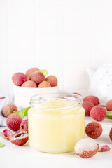 Homemade Lychee jam marmalade in jar, with fresh ripe lychees fruits on white table background, copy space