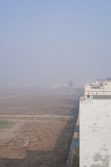 Polluted air. Gray, beige haze in a residential area on a sunny day. Poor visibility in the suburbs due to heavy smog from factory emissions and agricultural activities. Environmental pollution.