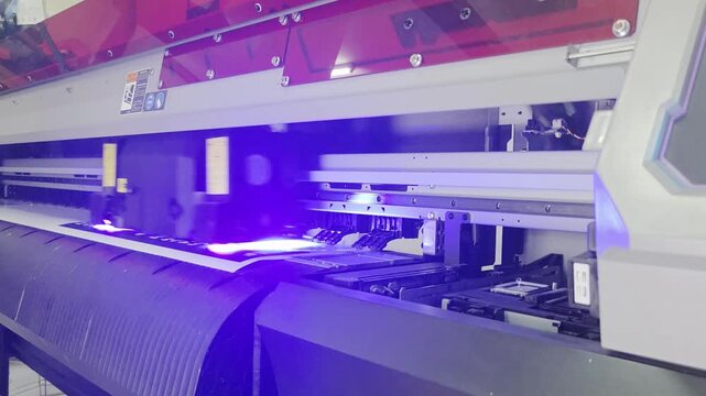 Large Format Printer in Operation Printing Graphics on Roll of Paper.