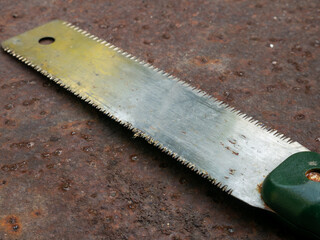 Rusty Japanese Pull Saw on Ground: Old Nokogiri Woodworking Tool Close-up Weathered Concrete Surface Detail