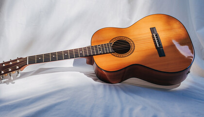 Classic acoustic guitar on white fabric background.