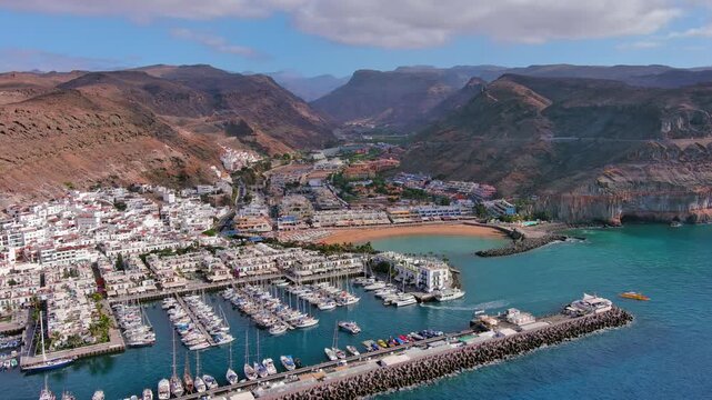 Puerto de Mogan, Gran Canaria, Canary Islands, Spain: Aerial view of famous tourist resort town, beach Playa de Mogan, summer day with blue sky - landscape panorama of Atlantic Ocean islands from abov