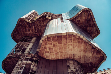 View of the House of Croatian Veterans, a brutalist monument, rises against the clear sky, showcasing weathered concrete and metallic accents, Crevarska Strana, Sisak-Moslavina County, Croatia.