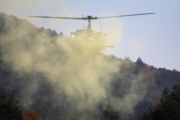 煙の中飛ぶヘリコプター