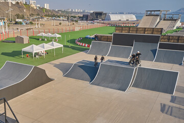 Obraz premium Bmx riders exercising and practicing freestyle tricks in a large outdoor urban skatepark