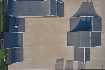 Obraz premium Bmx riders performing tricks in an urban skate park, creating long shadows