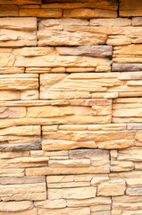 Sand stone texture closeup, decorative wall made of light yellow and brown sand stone
