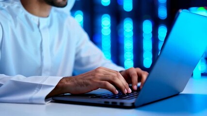 Middle eastern cybersecurity specialist working on laptop in data center server room, focusing on digital protection and network security - Powered by Adobe