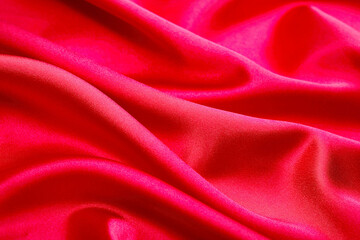 Bright pink-red satin fabric texture with shimmering folds, silky luxury textile perfect for beauty branding, fashion, glamour designs, and packaging.