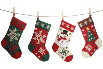 Four Christmas stockings hanging on a rope clothespins isolated on a transparent background