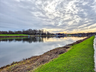 A landscape with a dramatic sky over a river.