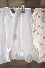 White baby bodysuits hanging in a row