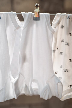 White baby bodysuits hanging in a row