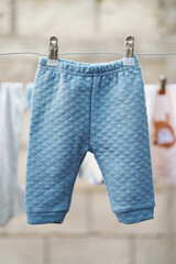 Quilted infant pants hanging in natural light