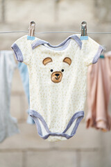Baby bodysuit with bear design hanging