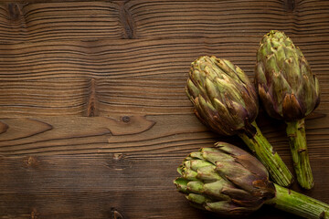 Obraz premium Whole heads of purple artichokes top view. Vegetables food ready to cook