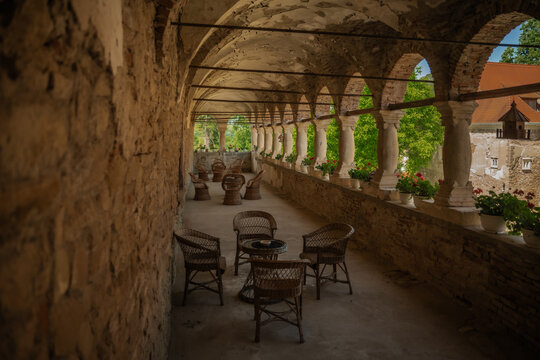 View of the arched terrace with stone walls, elegant columns, and inviting wicker furniture in the Bethlen Castle, Cris, Transilvania, Romania.