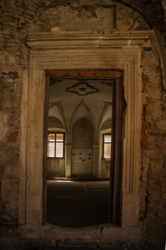 View of the Bethlen Castle's interior framed by a stone doorway reveals a room with arched ceilings and soft light filtering through windows, Cris, Transilvania, Romania.