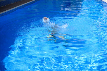 Drowning person's hands reaching for above water in swimming pool, needing assistance. Concept of water hazards, safety issues, and drowning risk.