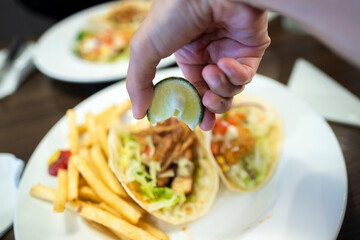 タコスとフライドポテトにライムをかける