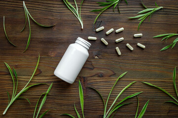 Alternative herbal medicine - herbs and pills on wooden table. Homeopathy treatment, top view