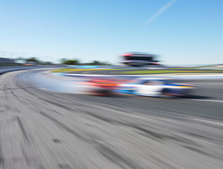 Classic american culture nascar racing car in motion blur in competition riding oval race track asphalt surface low angle view