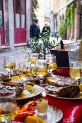 table of prawns and oysters and white wine close up on the historic street of lyon